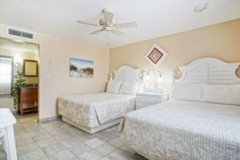 Double queen room with tropical decor and pool view at Glunz Ocean Beach Resort