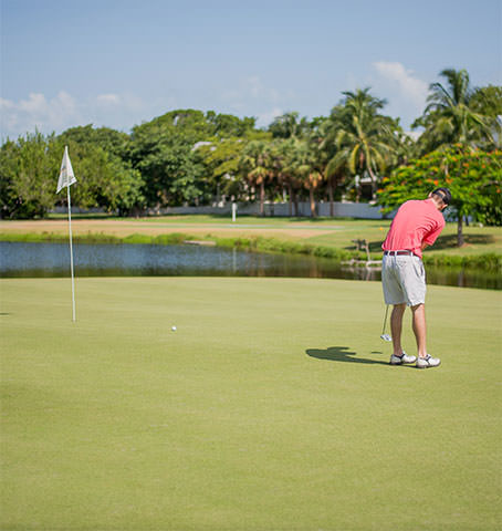 Man swings a club while playing golf