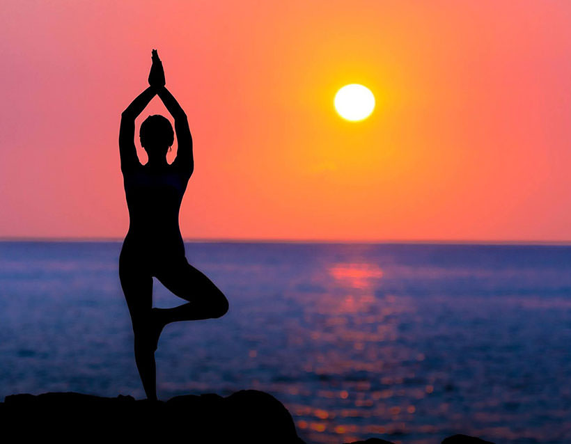 Female doing yoga at sunrise